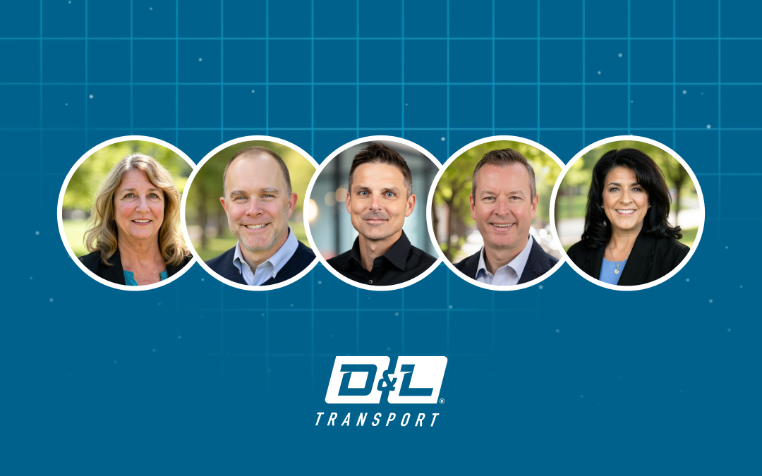 D&L Transport executive leadership team standing together, representing the company’s open-door philosophy and commitment to accessible leadership for Agents. The photo features five executives smiling confidently against a blue background with the D&L Transport logo, symbolizing